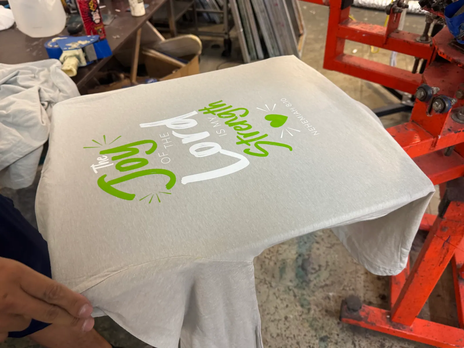 Heather gray T-shirt screen printed in green and white with The Joy of the Lord Is My Strength, Nehemiah 8:10